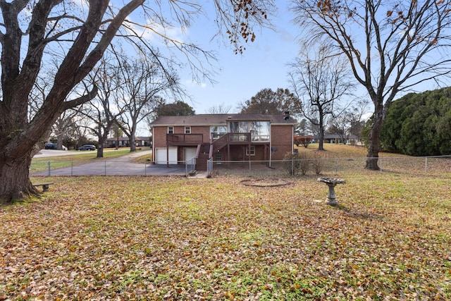 back of property featuring a garage, a yard, and a wooden deck