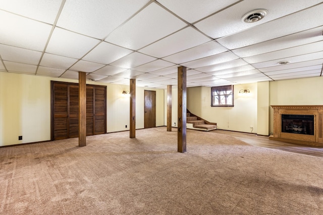 basement featuring a paneled ceiling and carpet floors