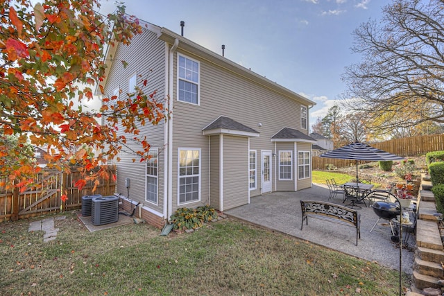 back of house featuring a patio area, central air condition unit, and a yard