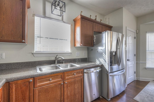 kitchen with dark hardwood / wood-style flooring, sink, stainless steel appliances, and a textured ceiling