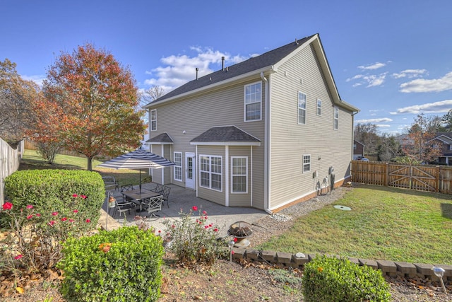 rear view of property featuring a lawn and a patio area