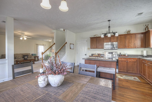 dining room featuring a textured ceiling, ceiling fan, and dark wood-type flooring