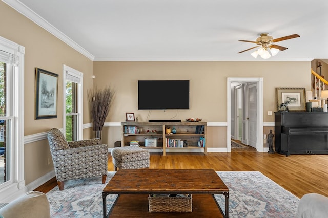 living room with wood-type flooring, ceiling fan, and ornamental molding