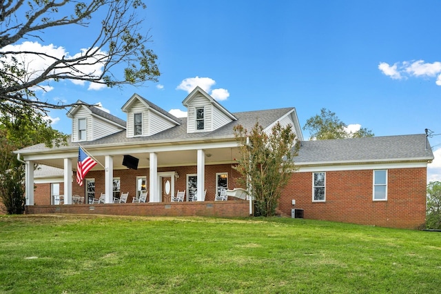 cape cod home with a porch, central AC unit, and a front lawn