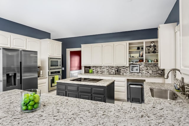 kitchen with light stone countertops, stainless steel appliances, sink, gray cabinets, and white cabinetry