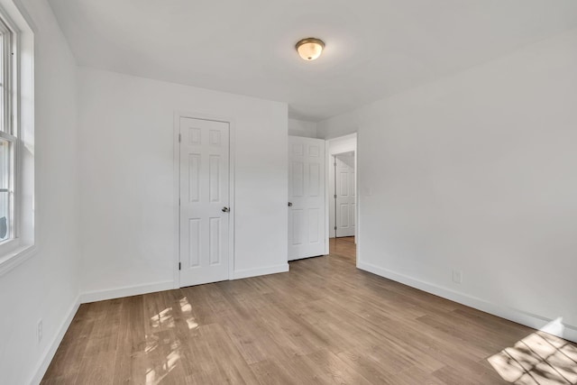 unfurnished bedroom with light wood finished floors and baseboards