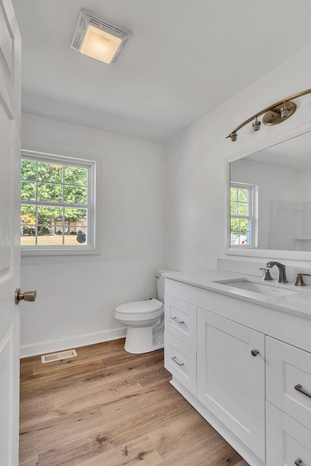 bathroom featuring visible vents, vanity, wood finished floors, and toilet