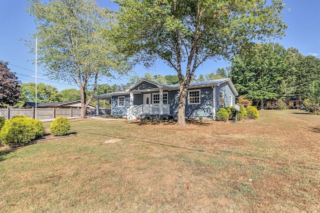 rear view of house with covered porch and a lawn