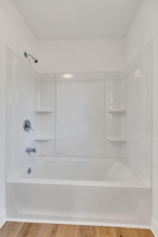 bathroom featuring tub / shower combination and wood finished floors