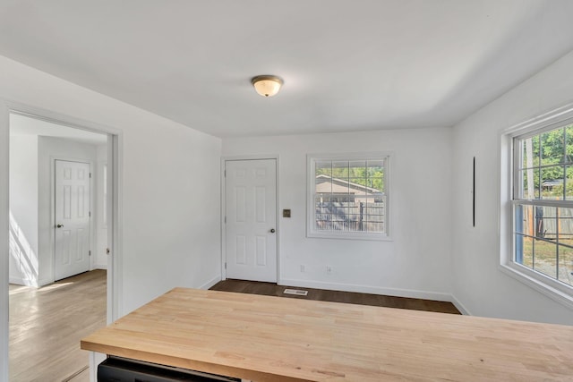 interior space with baseboards, dark wood-style flooring, and a wealth of natural light