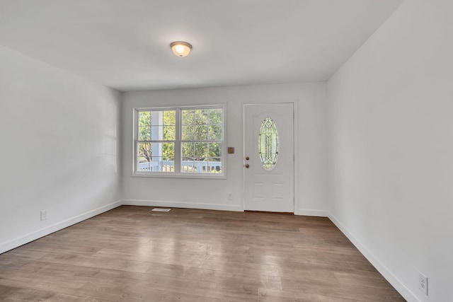 entrance foyer with wood finished floors, visible vents, and baseboards