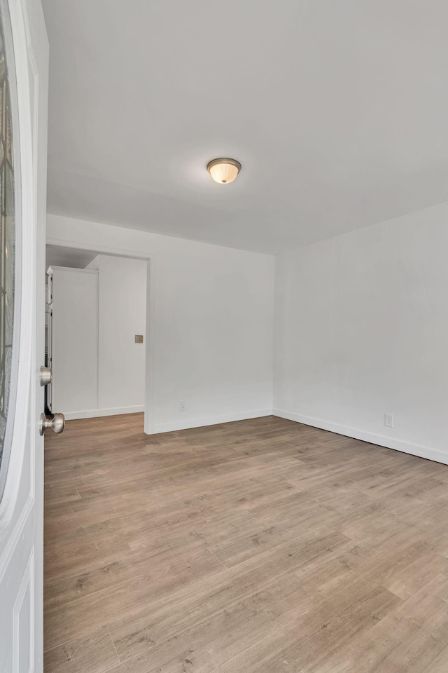 empty room featuring light wood-style floors and baseboards