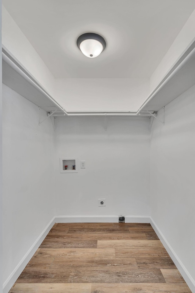 laundry room featuring laundry area, baseboards, wood finished floors, hookup for an electric dryer, and washer hookup