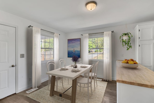 dining space with visible vents, plenty of natural light, and wood finished floors