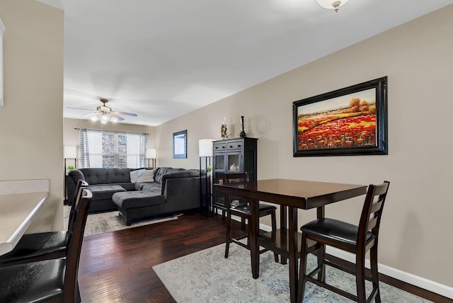 dining space with ceiling fan and dark wood-type flooring