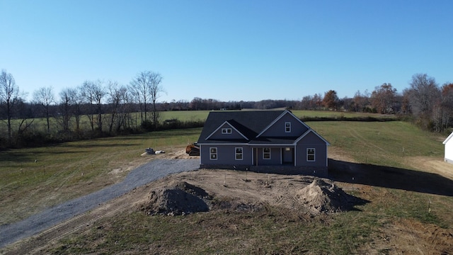 view of front of property featuring a front lawn and a rural view