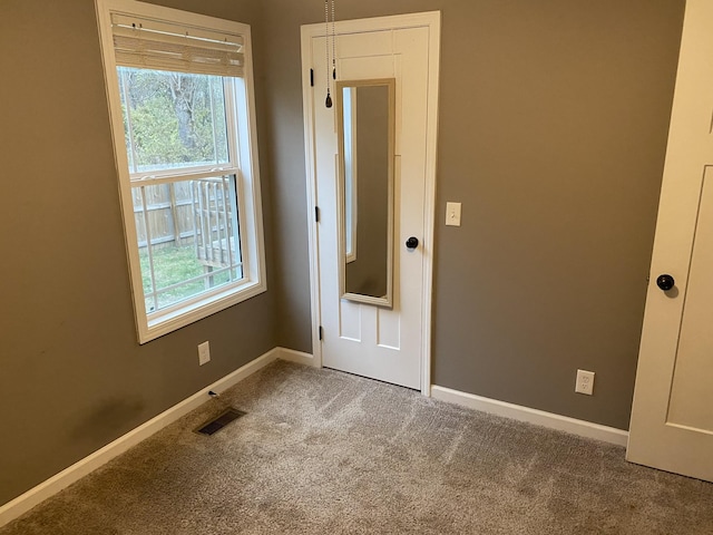 unfurnished room with a healthy amount of sunlight and carpet