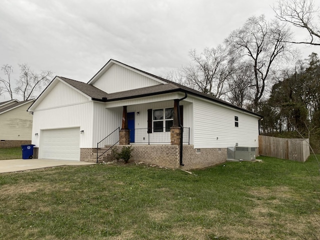 view of front facade with a garage, central AC, a front lawn, and covered porch