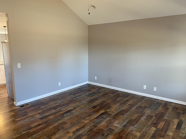 empty room with vaulted ceiling and dark hardwood / wood-style floors