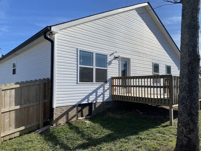 view of side of home featuring a wooden deck and a lawn