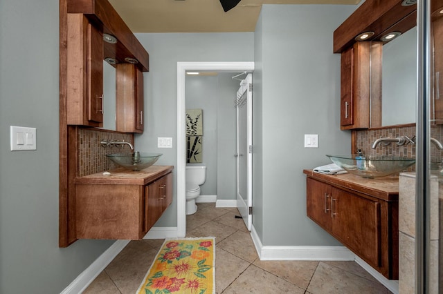 bathroom featuring tasteful backsplash, tile patterned flooring, and vanity