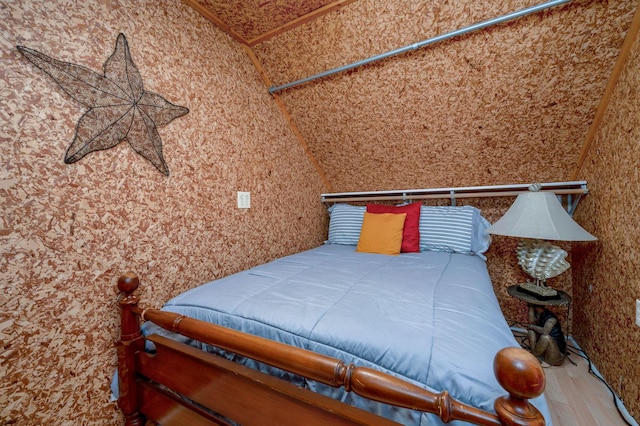 unfurnished bedroom with wood-type flooring and vaulted ceiling