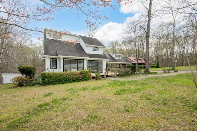 rear view of house with a lawn and a wooden deck