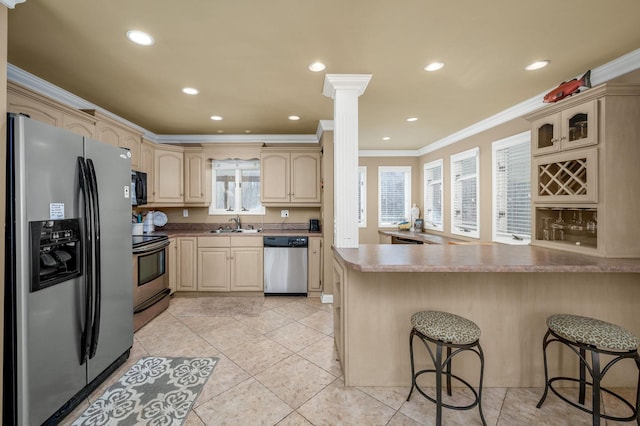 kitchen featuring a breakfast bar, appliances with stainless steel finishes, kitchen peninsula, and ornamental molding