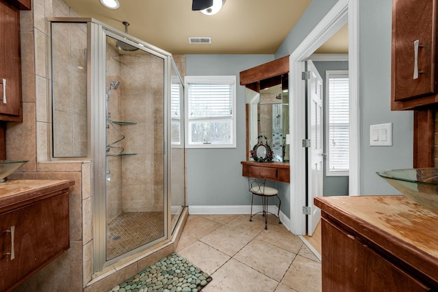 bathroom featuring tile patterned flooring, vanity, and a shower with shower door