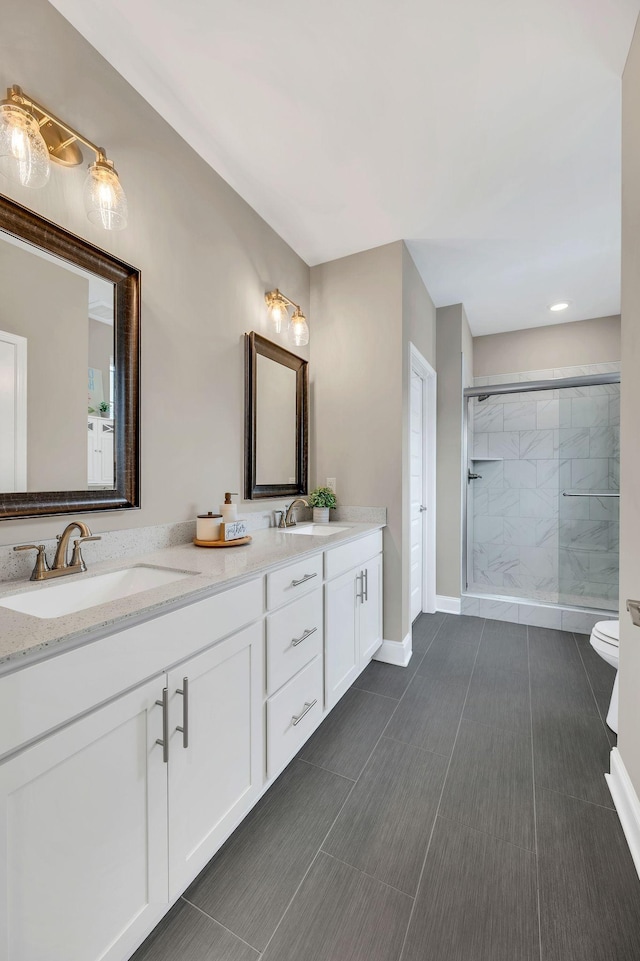 bathroom featuring tile patterned floors, vanity, toilet, and a shower with shower door