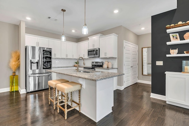 kitchen featuring dark hardwood / wood-style flooring, stainless steel appliances, sink, stone counters, and white cabinetry