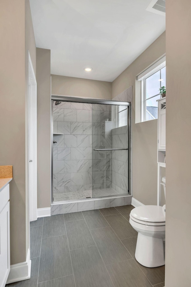 bathroom with tile patterned floors, vanity, toilet, and walk in shower