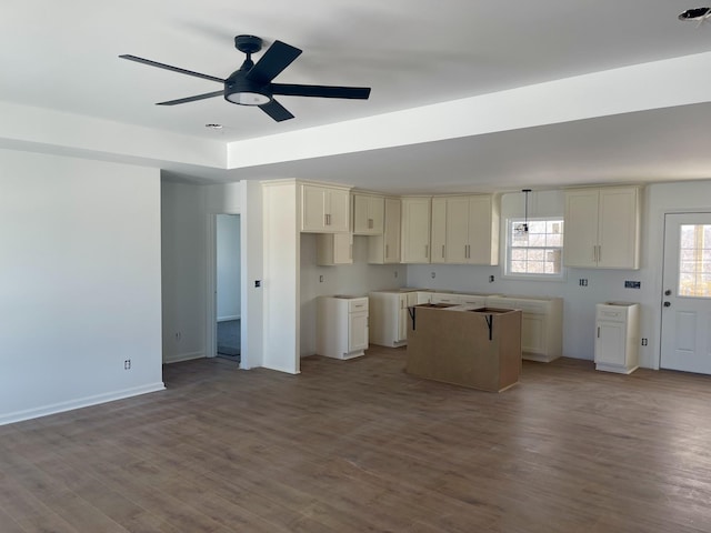 kitchen featuring ceiling fan, wood-type flooring, and cream cabinetry