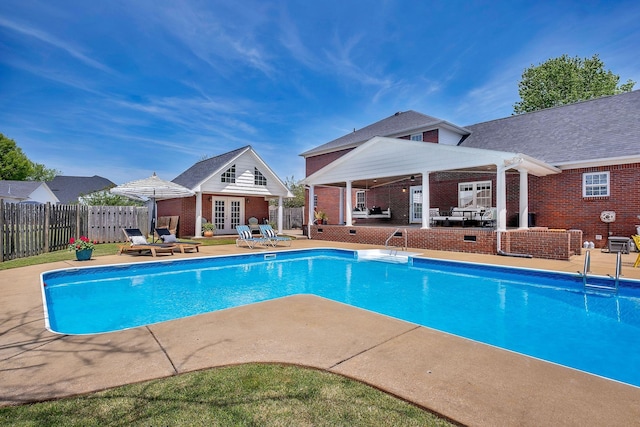 view of pool with french doors, an outdoor structure, and a patio