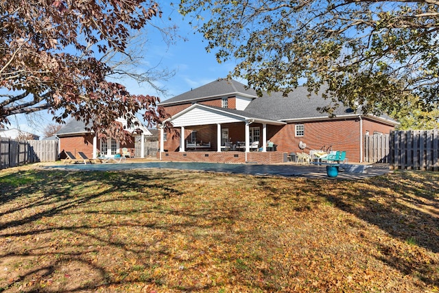 rear view of house featuring a yard and a patio