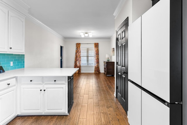 kitchen featuring white cabinetry, dark wood-type flooring, crown molding, and kitchen peninsula