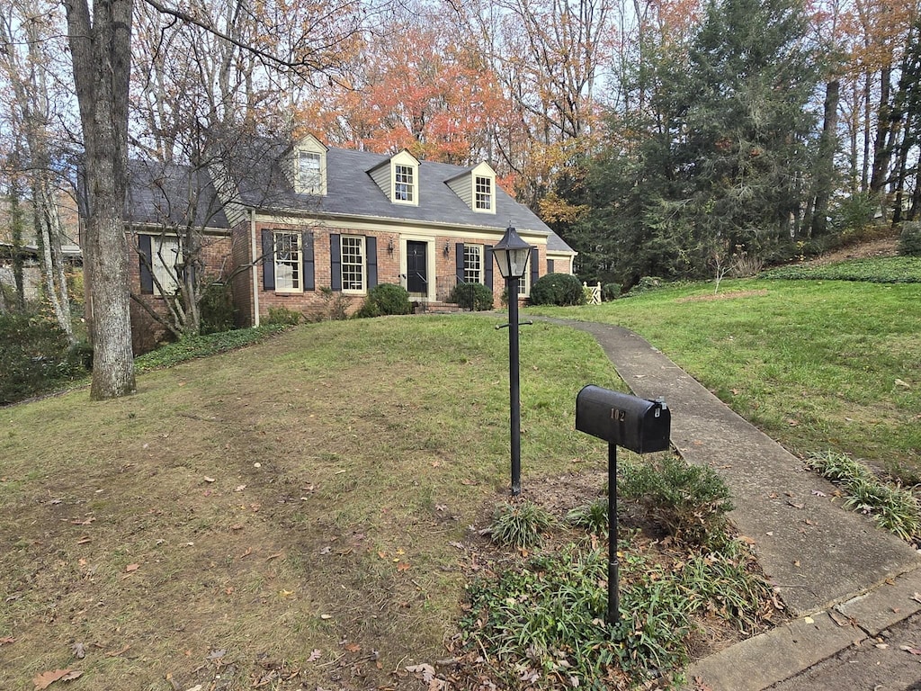 cape cod-style house featuring a front yard