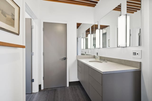 bathroom featuring beam ceiling, vanity, and wood-type flooring