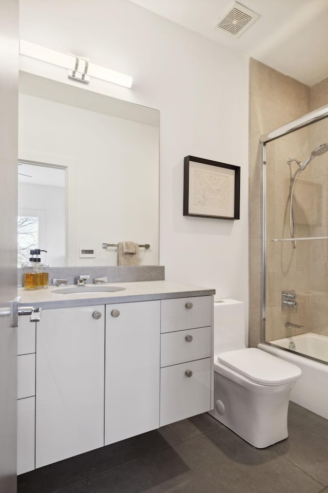 full bathroom featuring tile patterned flooring, vanity, toilet, and bath / shower combo with glass door