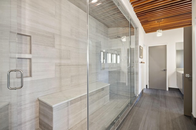 bathroom with a shower with door and vanity