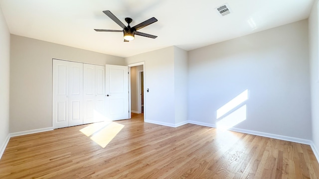 unfurnished bedroom with ceiling fan, a closet, and light hardwood / wood-style flooring