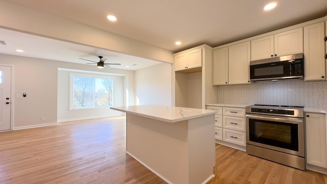 kitchen featuring a center island, white cabinets, light hardwood / wood-style flooring, and appliances with stainless steel finishes