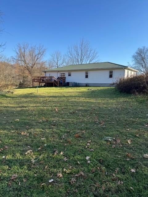 back of property featuring a yard and a deck