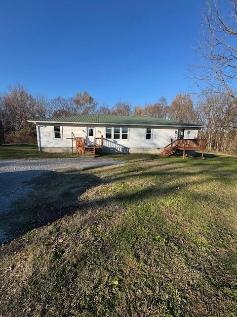 view of front of house with a deck and a front yard