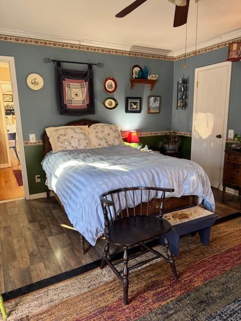 bedroom with crown molding, ceiling fan, and dark hardwood / wood-style floors