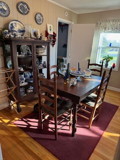 dining space with crown molding and wood-type flooring