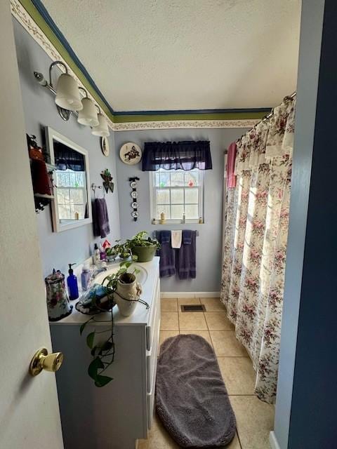 bathroom featuring tile patterned flooring, vanity, and a textured ceiling