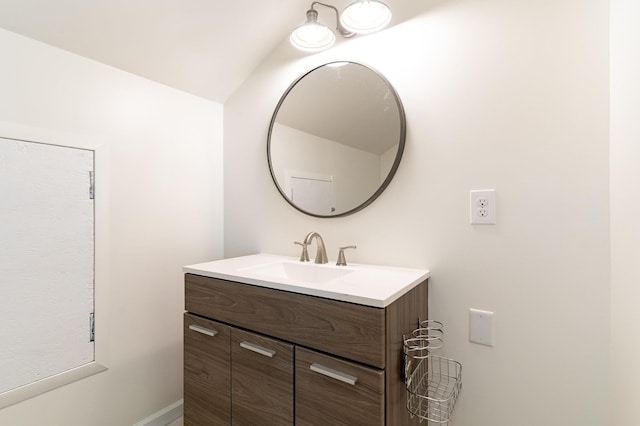 bathroom with vanity and lofted ceiling