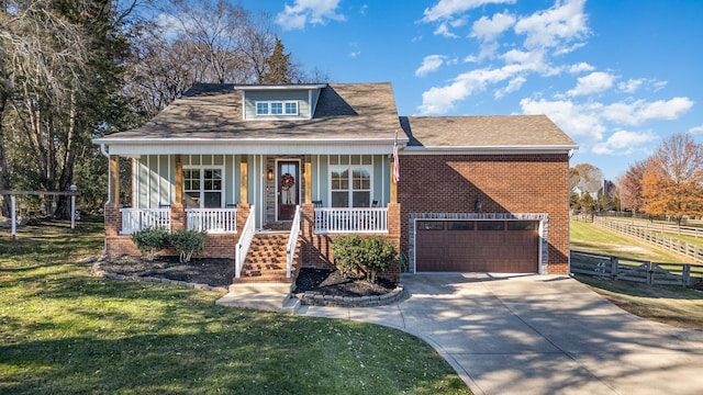 view of front of property with a front yard, a porch, and a garage