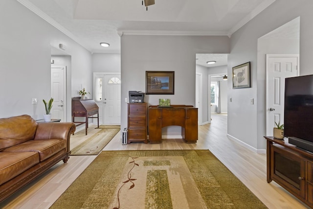 living room with ceiling fan, ornamental molding, and light wood-type flooring